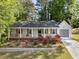Charming single-Gathering home featuring a cozy front porch and a well-maintained lawn with blossoming rose bushes at 874 Fox Valley Dr, Stone Mountain, GA 30088