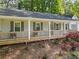 Relaxing front porch featuring wooden flooring, comfortable chairs, and views of a lush, blossoming garden at 874 Fox Valley Dr, Stone Mountain, GA 30088