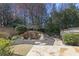 Backyard featuring a waterfall feature, stone pathway, wooden fence, and mature landscaping at 10462 Bent Tree Vw, Duluth, GA 30097