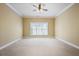Large bedroom with plush carpet, crown molding, and a window with natural light at 10462 Bent Tree Vw, Duluth, GA 30097