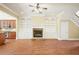 Warm living room with fireplace, built-in shelving, and hardwood floors open to the kitchen and staircase at 10462 Bent Tree Vw, Duluth, GA 30097