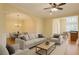 Bright living room with hardwood floors, neutral furniture, and an open layout to the dining area at 10462 Bent Tree Vw, Duluth, GA 30097