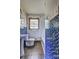 Well-lit bathroom featuring a toilet, sink, window, blue mosaic tiles, and a bathtub at 1815 Windsor Sw Dr, Atlanta, GA 30311