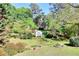 Overhead shot of landscaped backyard with lush greenery, storage shed, flower garden, and small fountain feature at 3740 Laurel Brook Way, Snellville, GA 30039