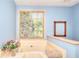 Bright bathroom with a large soaking tub next to a large window at 3740 Laurel Brook Way, Snellville, GA 30039