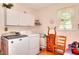 Bright laundry room with front load washer and dryer and white cabinets at 3740 Laurel Brook Way, Snellville, GA 30039