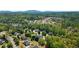 Scenic aerial view showcasing the neighborhood with mature trees, rolling hills, and a mountain backdrop at 4030 Scenic View Ct, Cumming, GA 30028