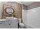 Stylish bathroom with hardwood floors, a marble countertop sink and wooden accent wall above the tub at 4030 Scenic View Ct, Cumming, GA 30028