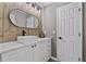 Stylish half-bath with a vessel sink, modern faucet, and wood-look tile accent wall at 4030 Scenic View Ct, Cumming, GA 30028