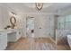 Elegant bathroom with marble walls, wood-look tile floors, a soaking tub, and a glass-enclosed shower at 4030 Scenic View Ct, Cumming, GA 30028