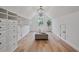Large, bright walk-in closet with custom shelving, hardwood floors and an ottoman with light fixture at 4030 Scenic View Ct, Cumming, GA 30028