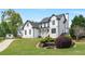 Beautiful two-story home with white siding, black roof, a landscaped yard and a charming front porch at 4030 Scenic View Ct, Cumming, GA 30028