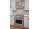 Stainless steel kitchen range, custom backsplash, and modern cabinetry at 4030 Scenic View Ct, Cumming, GA 30028