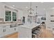 Bright kitchen with a farmhouse sink, quartz countertop, and island with bar stool seating at 4030 Scenic View Ct, Cumming, GA 30028