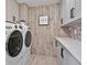 Modern laundry room features gray cabinets, quartz countertops, hardwood floors and stainless steel washer and dryer at 4030 Scenic View Ct, Cumming, GA 30028
