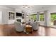 Bright living room with hardwood floors, built-in shelving, fireplace, and large windows offering a great view at 4815 Amble Trce, Cumming, GA 30040