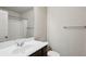 This bright bathroom features a white sink and vanity, and a shower with curtain rod at 6595 Story Cir, Norcross, GA 30093