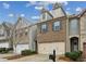 Charming townhome featuring a two-car garage and brick facade, complemented by manicured landscaping at 6595 Story Cir, Norcross, GA 30093