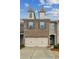 Attractive townhome showcasing a two-car garage, brick facade, and well-maintained front yard at 6595 Story Cir, Norcross, GA 30093