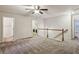 Spacious loft area with ceiling fan, carpet, and access to the laundry room at 6595 Story Cir, Norcross, GA 30093