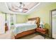 Well-lit bedroom with light green walls and carpet, featuring a wooden bed set and fan at 20 Queensland Ln, Covington, GA 30016