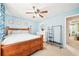 Bedroom with wood-framed bed, neutral walls, ceiling fan, and bright light from the entry way at 20 Queensland Ln, Covington, GA 30016