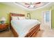 Well-lit bedroom with light green walls and carpet, featuring a wooden bed set and ceiling fan at 20 Queensland Ln, Covington, GA 30016