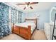 Cozy bedroom with wood-framed bed, white dresser, and blue patterned curtains for an inviting space at 20 Queensland Ln, Covington, GA 30016