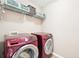 Well-equipped laundry room with modern, red Samsung washer and dryer and ample storage space at 20 Queensland Ln, Covington, GA 30016