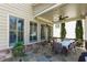 Relax on this covered back porch with stone flooring and an outdoor dining area at 2601 Boulder Way, Woodstock, GA 30188