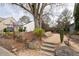 The welcoming entrance features stone accents and a lush garden, setting a tone for the community at 2601 Boulder Way, Woodstock, GA 30188