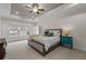 Bright main bedroom with a ceiling fan, tray ceiling and large windows at 2601 Boulder Way, Woodstock, GA 30188