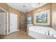 Bathroom with a shower, large soaking tub and a decorative hanging light at 548 Myrtle Trace Ln, Suwanee, GA 30024