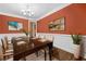 Formal dining room with dark wood table, chandelier, and decorative artwork at 548 Myrtle Trace Ln, Suwanee, GA 30024
