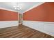 The dining room features hardwood floors, an elegant chandelier, and decorative wainscoting at 548 Myrtle Trace Ln, Suwanee, GA 30024