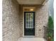 A front door features a glass window insert, brick exterior, and black railing at 548 Myrtle Trace Ln, Suwanee, GA 30024