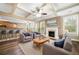 Cozy living room with fireplace, ceiling fan, and ample natural light at 548 Myrtle Trace Ln, Suwanee, GA 30024