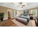 Spacious main bedroom with tray ceilings, a ceiling fan, and an ensuite bathroom at 548 Myrtle Trace Ln, Suwanee, GA 30024