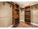 Walk-in closet with custom shelving and hardwood floors at 548 Myrtle Trace Ln, Suwanee, GA 30024