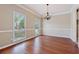 Elegant dining room with hardwood floors, decorative chandelier, and natural light from large windows at 1632 Chadwick Ridge Dr, Lawrenceville, GA 30043