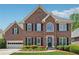 Charming brick home featuring a well-manicured lawn, black shutters, and an attached two-car garage at 1632 Chadwick Ridge Dr, Lawrenceville, GA 30043