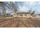Backyard view with an expansive lawn and a house featuring a prominent brick chimney at 2426 Windridge Dr, Conyers, GA 30013