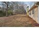 Large backyard showcasing a spacious grassy area with mature trees and side of house at 2426 Windridge Dr, Conyers, GA 30013