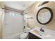 Bathroom features a bathtub/shower combination, vanity with a dark cabinet, and a decorative mirror at 2426 Windridge Dr, Conyers, GA 30013