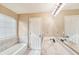 Well-lit bathroom featuring a tub with tile accents and a marble countertop sink at 2426 Windridge Dr, Conyers, GA 30013
