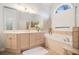 Bright bathroom with a large tub, neutral tiling and vanity with double sinks at 2920 Stanway Ave, Douglasville, GA 30135