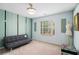 Bedroom featuring striped wallpaper accent wall, gray futon and lighted ceiling fan at 2920 Stanway Ave, Douglasville, GA 30135