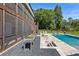 Expansive backyard with a screened-in porch, pool, outdoor fireplace, and lush green landscaping at 445 Roper Rd, Canton, GA 30115