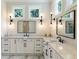 This modern bathroom features double sinks, white cabinets, marble countertops, and unique modern lighting at 445 Roper Rd, Canton, GA 30115
