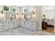 This bathroom features double sinks, white cabinets, marble countertops and modern lighting and tile at 445 Roper Rd, Canton, GA 30115